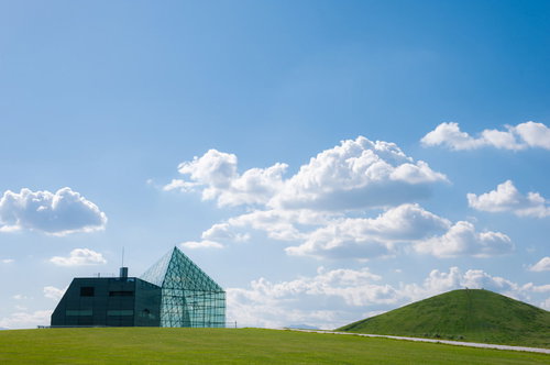 青空の下、緑の丘に建つガラスのピラミッド（モエレ沼公園）