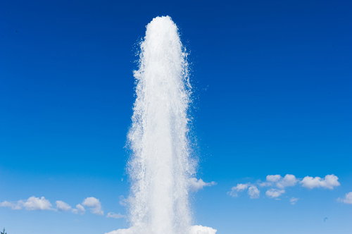 モエレ沼公園の丘に高く上がる噴水と青空の風景