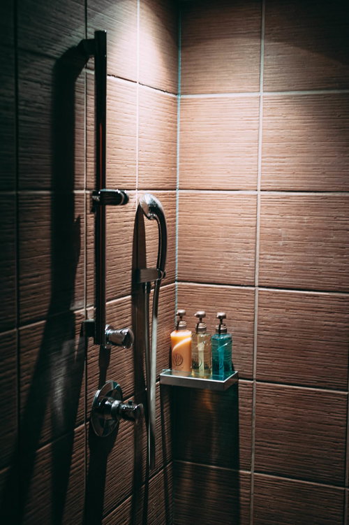 薄暗くライトアップされたシャワー室のバスルームアメニティ