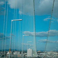 明石大橋の吊橋と車道を見上げた構図、白いケーブルの放射状構造の写真