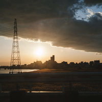 夕暮れと鉄塔のシルエット～夕焼け空に浮かぶ電力インフラの写真