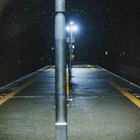 降雪中の深夜駅ホーム、街灯に照らされた静寂の空間の写真