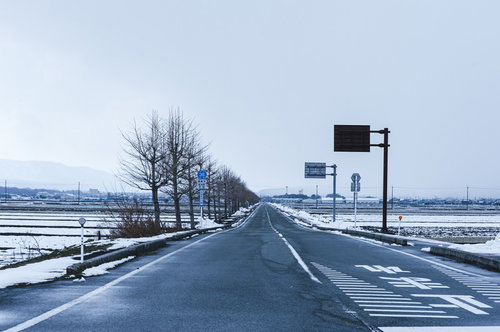 どこまでも続く雪化粧の車道と冬景色