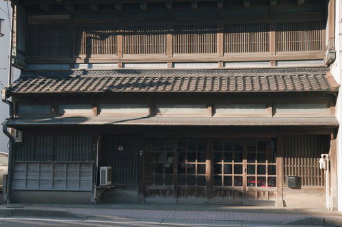 格子戸と木製看板の古い木造民家