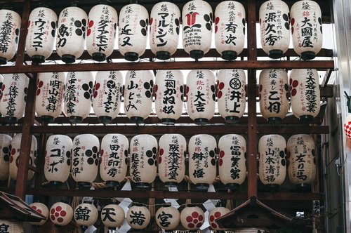 錦天満宮の境内に吊るされた白い提灯と参拝者の祈願