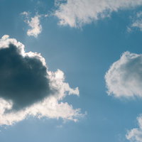 太陽に雲がかかった青空の光景と日光が差し込む自然風景の写真