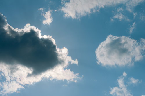太陽に雲がかかった青空の光景と日光が差し込む自然風景