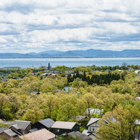 湖西道路から見下ろす琵琶湖と屋根、木々の町並みの写真