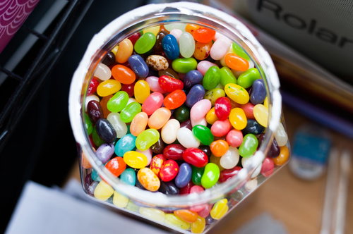 デスクに置かれたガラス容器のカラフルなジェリービーンズ壺買い