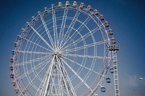 快晴の青空に映える白い観覧車の遊園地風景