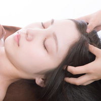 ヘッドマッサージを受けてリラックスする女性の顔の写真