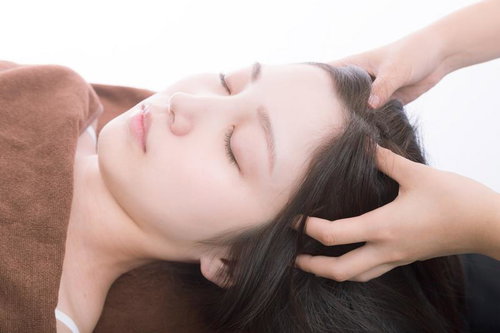 ヘッドマッサージを受けてリラックスする女性の顔