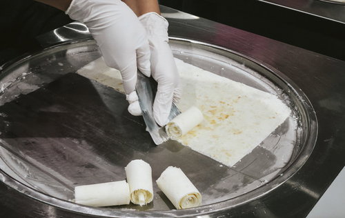 ロールアイスを鉄板で成形する手元の調理作業