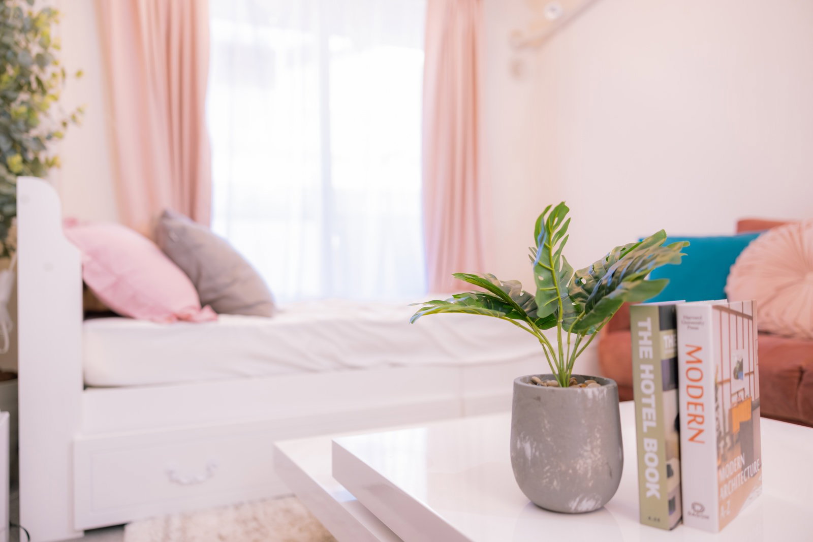 ピンクと白を基調としたワンルームのベッドルーム兼リビング空間