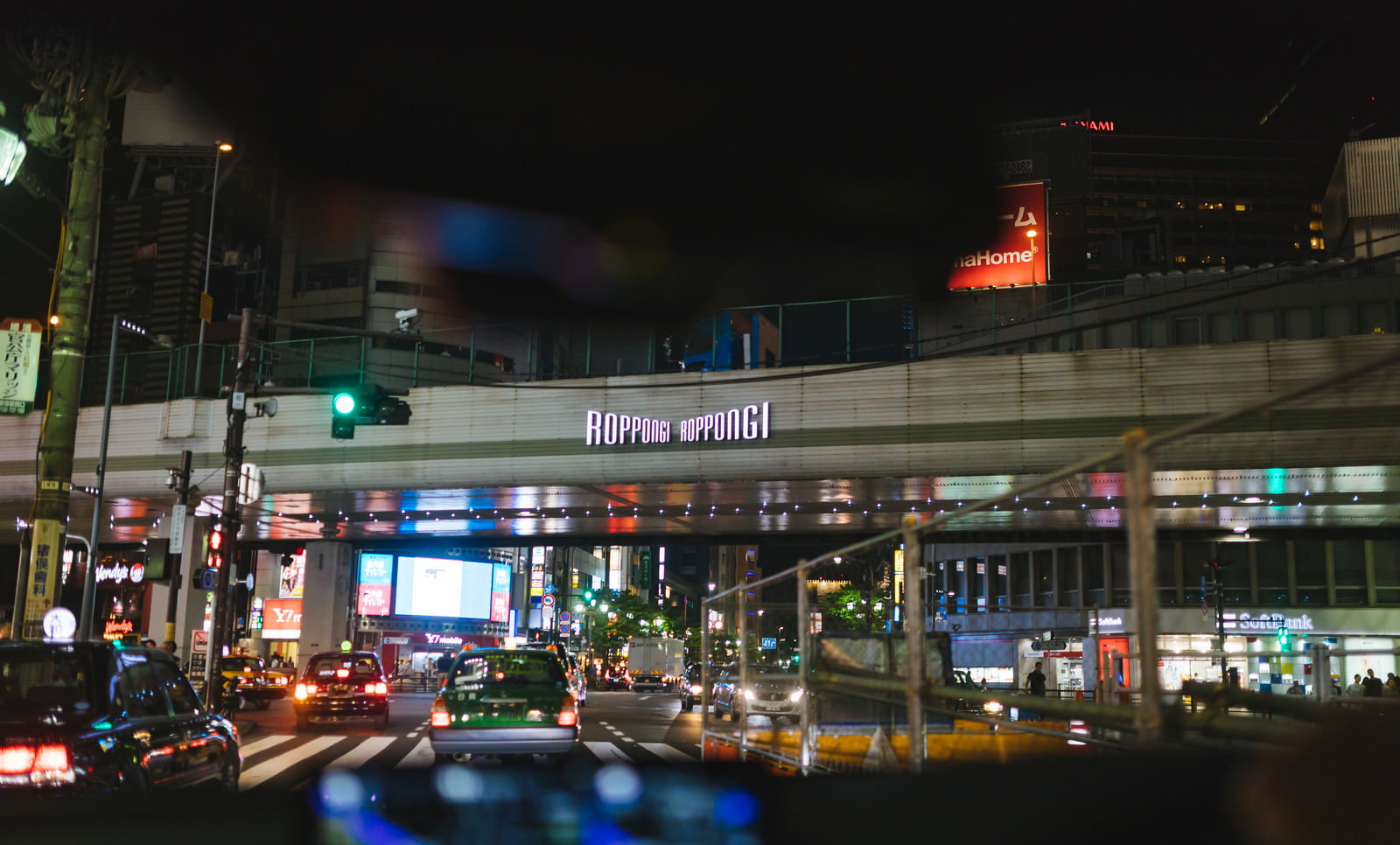 夜の六本木交差点でネオンが光る繁華街の風景