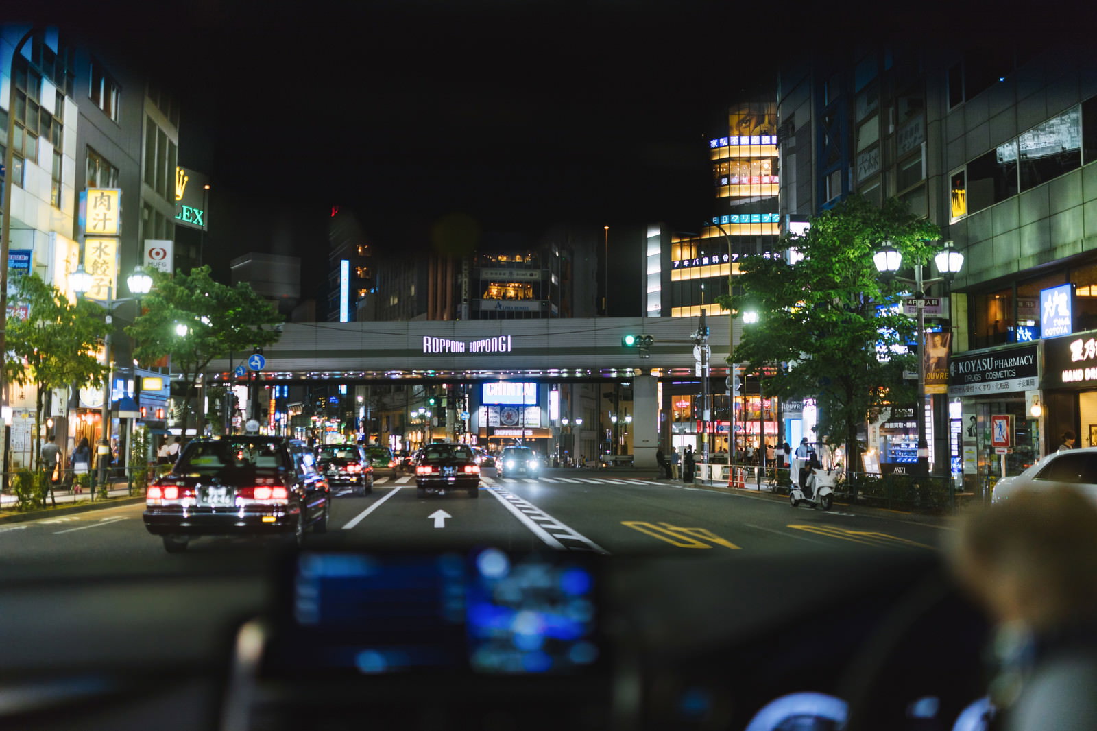 夜の六本木交差点でタクシーが往来する様子を車内から撮影した写真