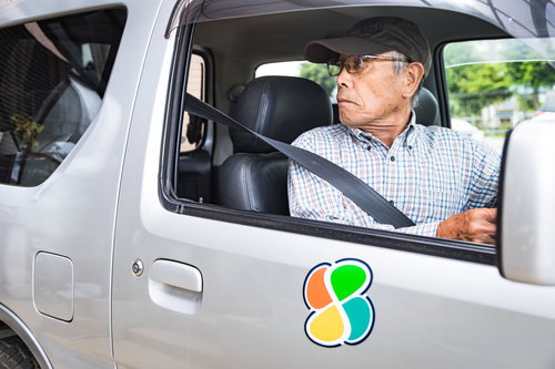 駐車スペースにバックする高齢者運転手 - 軽トラック