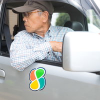 車内で後方を目視確認する高齢ドライバーの安全運転の写真