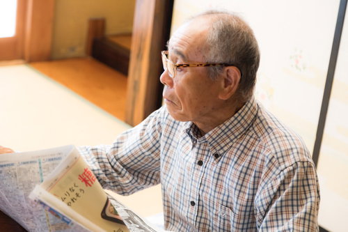 居間で新聞を読むお爺さん