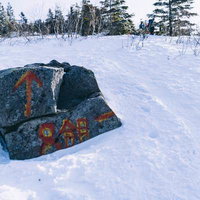 雪に埋もれた四阿山八合目の登山道標識と冬山登山ルートの写真