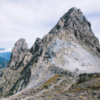 槍ヶ岳の穂先と小槍を望む北アルプスの登山道の写真