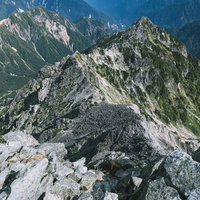 槍ヶ岳山頂からみる北鎌尾根の岩稜と山々の景観の写真