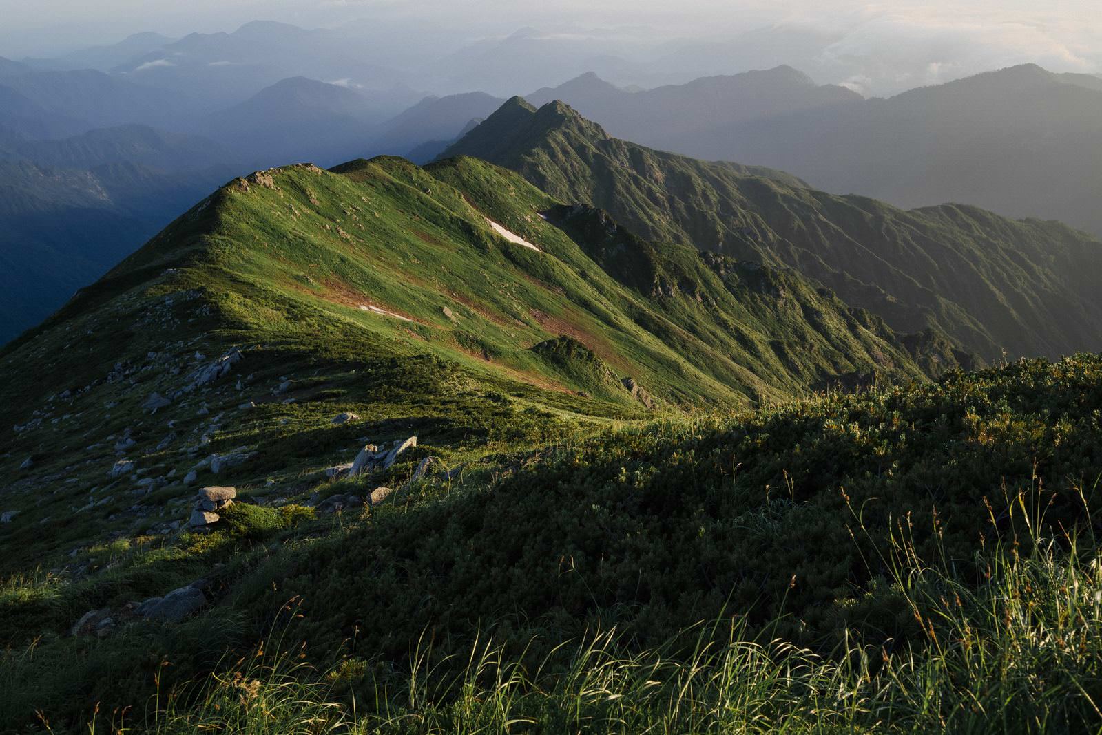 夜明けの飯豊本山からダイクラ尾根を眺める山岳風景