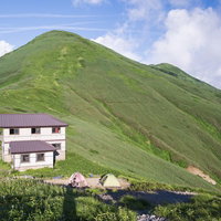 飯豊山の梅花皮小屋と山稜の景観の写真