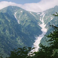 飯豊山の石転び沢遠景：残雪と新緑が織りなす日本百名山の絶景の写真