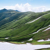飯豊本山全景と残雪の稜線の写真