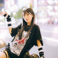 夜の繁華街で片手ピースをする女子のナイトファッションポーズの写真