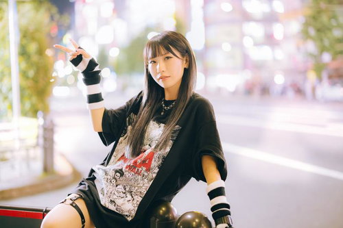 夜の繁華街で片手ピースをする女子のナイトファッションポーズ