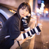 エナドリ片手に待ち合わせ時間を潰す女性のカジュアルファッションの写真