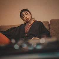 ソファーで居眠りする疲れた女性、黒いジャケット姿で休息の写真