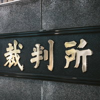 裁判所前に来ました。グレーの壁面に刻まれた看板の写真