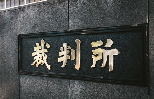 裁判所前に来ました。グレーの壁面に刻まれた看板