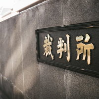 桜田通り前の裁判所の看板と石造りの建物入口の写真