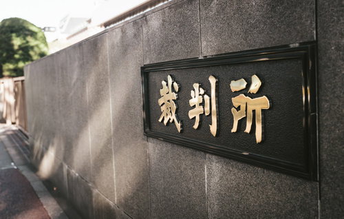 桜田通り前の裁判所の看板と石造りの建物入口