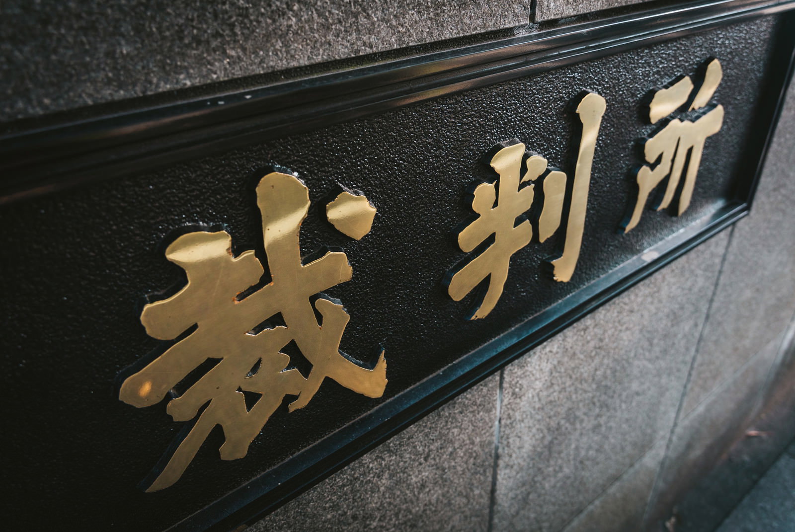 金色の文字で「裁判所」と書かれた黒い看板