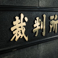 東京高裁前の裁判所と書かれた黒い石造の看板の写真