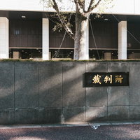 石造りの門構えを持つ裁判所前の様子の写真