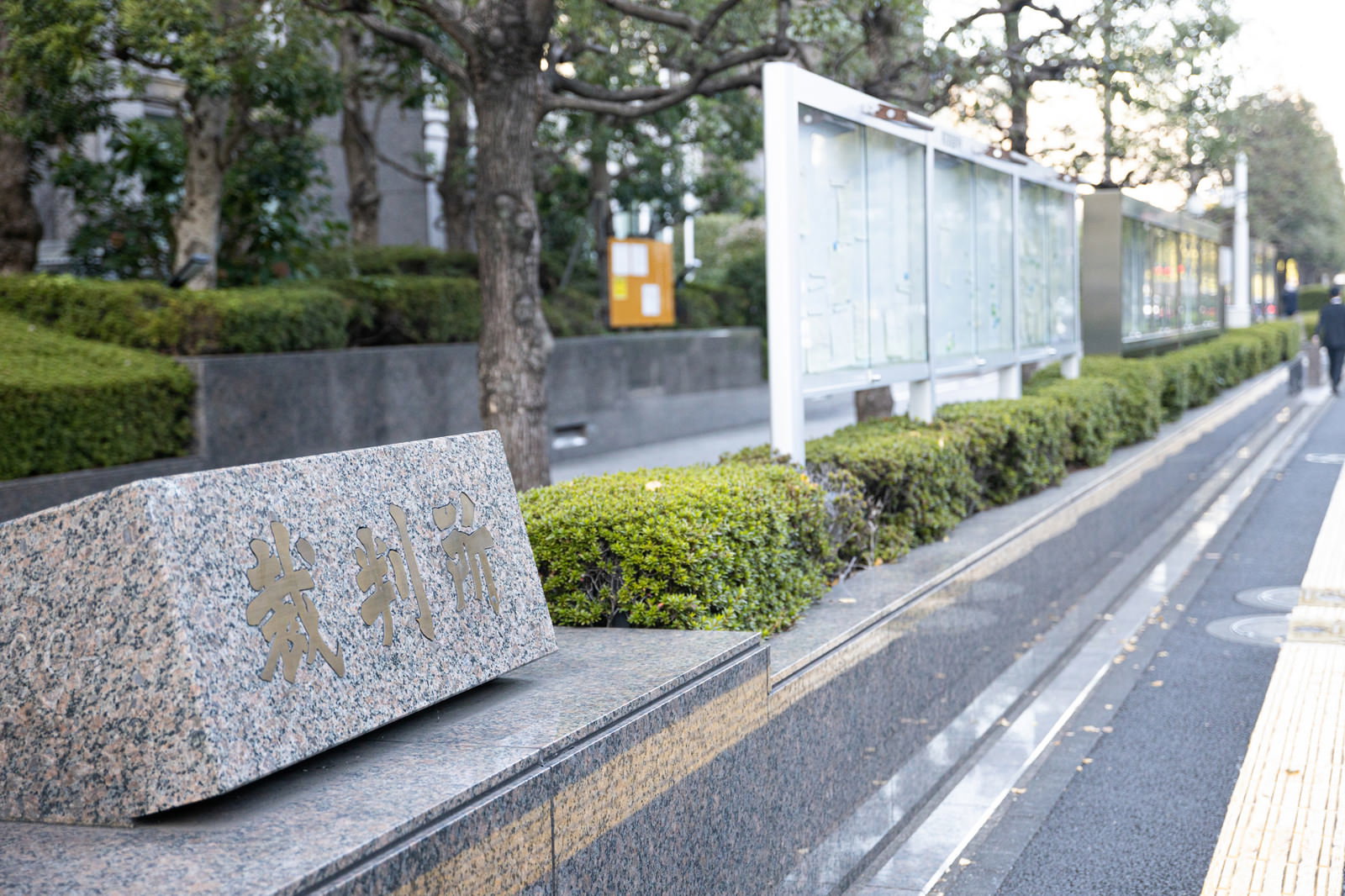 石造りの外壁と植栽が整備された東京家庭裁判所前の歩道