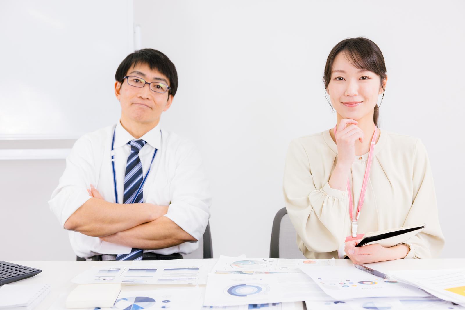 オフィスでタブレットを持ち、資料を見ながら考える男性と女性［モデル：ガーミー SAKI］
