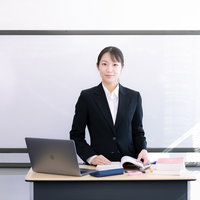 セミナー会場で登壇してプレゼンテーションを行う女性講師の写真