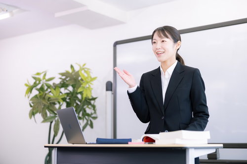 ホワイトボード前で商品説明する女性社員の研修風景