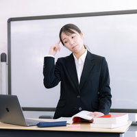 黒いスーツを着た困惑する女性講師がセミナーで悩むの写真