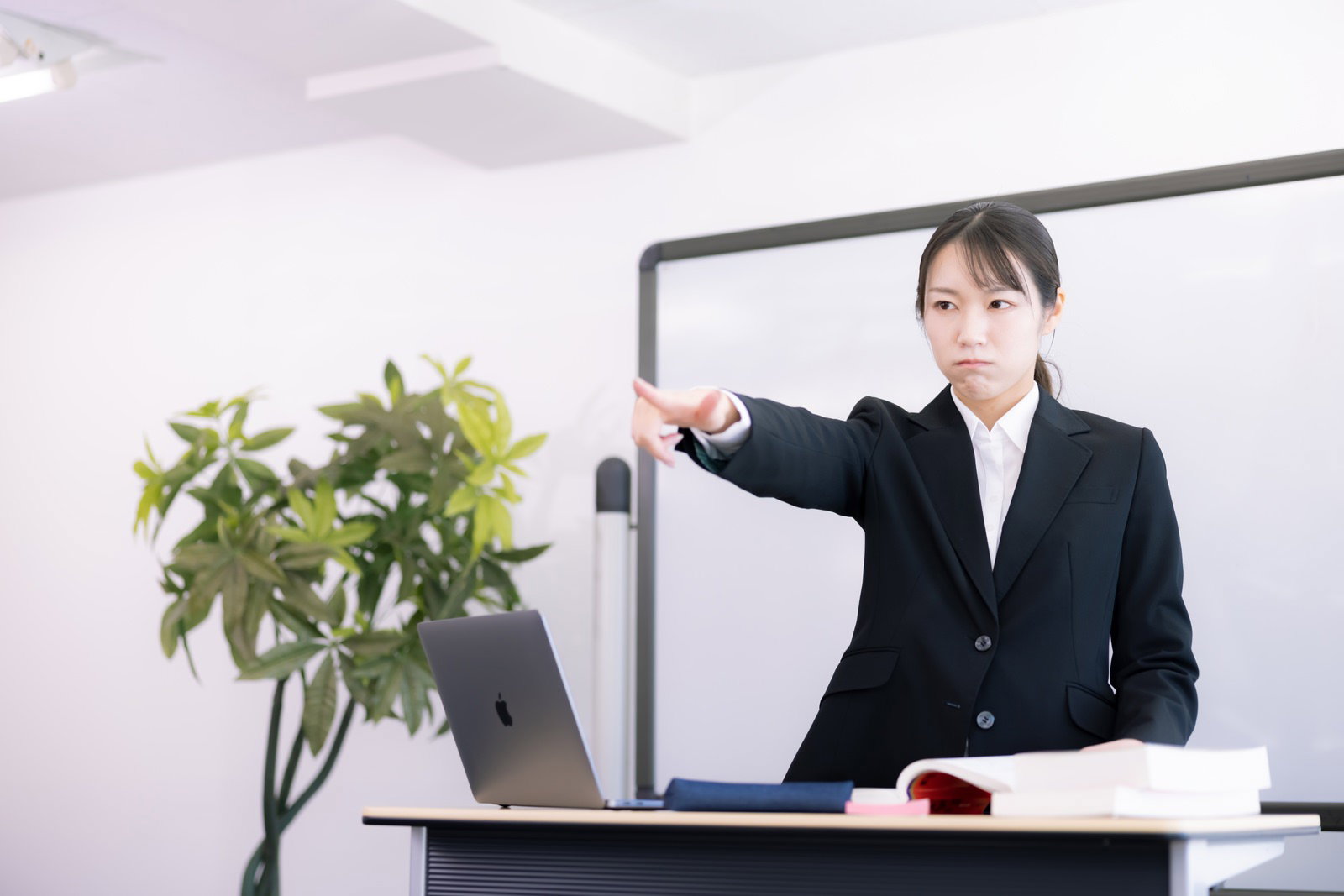 セミナーで指さし注意する女性講師［モデル：SAKI］