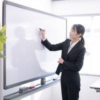 ホワイトボードで商品説明する女性講師のセミナー・研修風景の写真