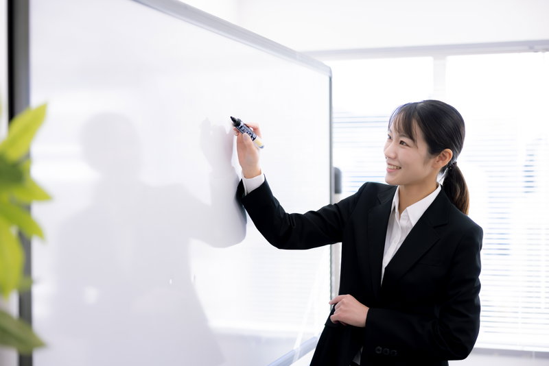 笑顔で講演中の女性講師のフリー素材