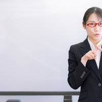 不合格のバツサインを出す女性講師の厳しい指導の写真